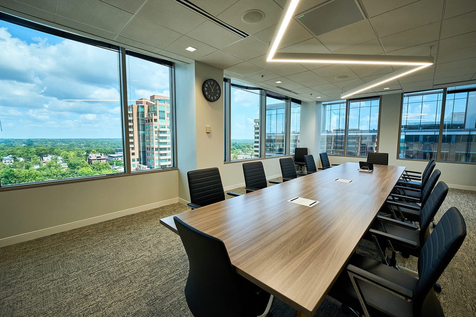 A Belden boardroom with a long wood table and floor to ceiling windows looking out over the St. Louis skyline, corporate office photography