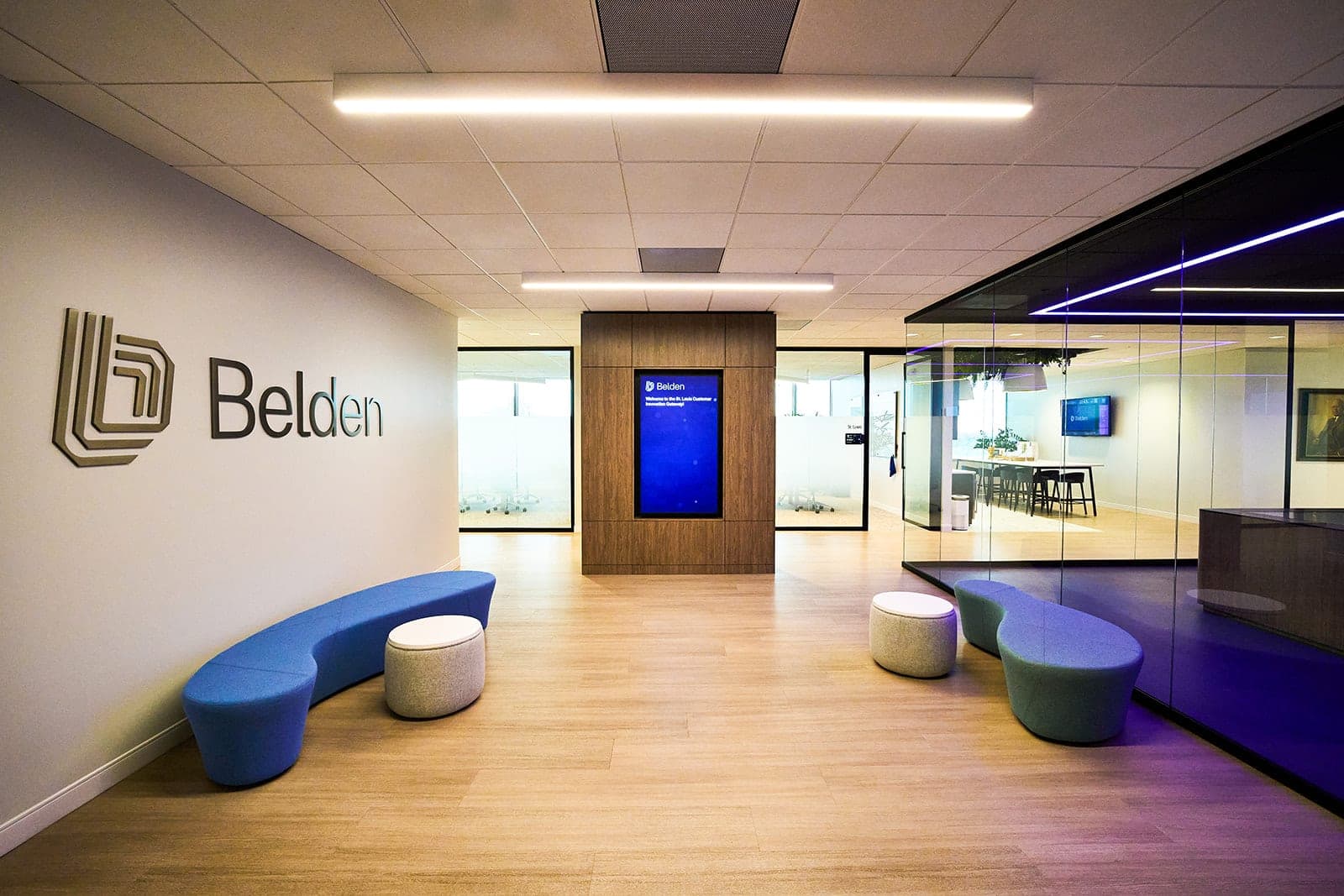 Wider view of the Belden reception area in St. Louis with two seating clusters and a glass-walled meeting room, architectural photography for a corporate workplace