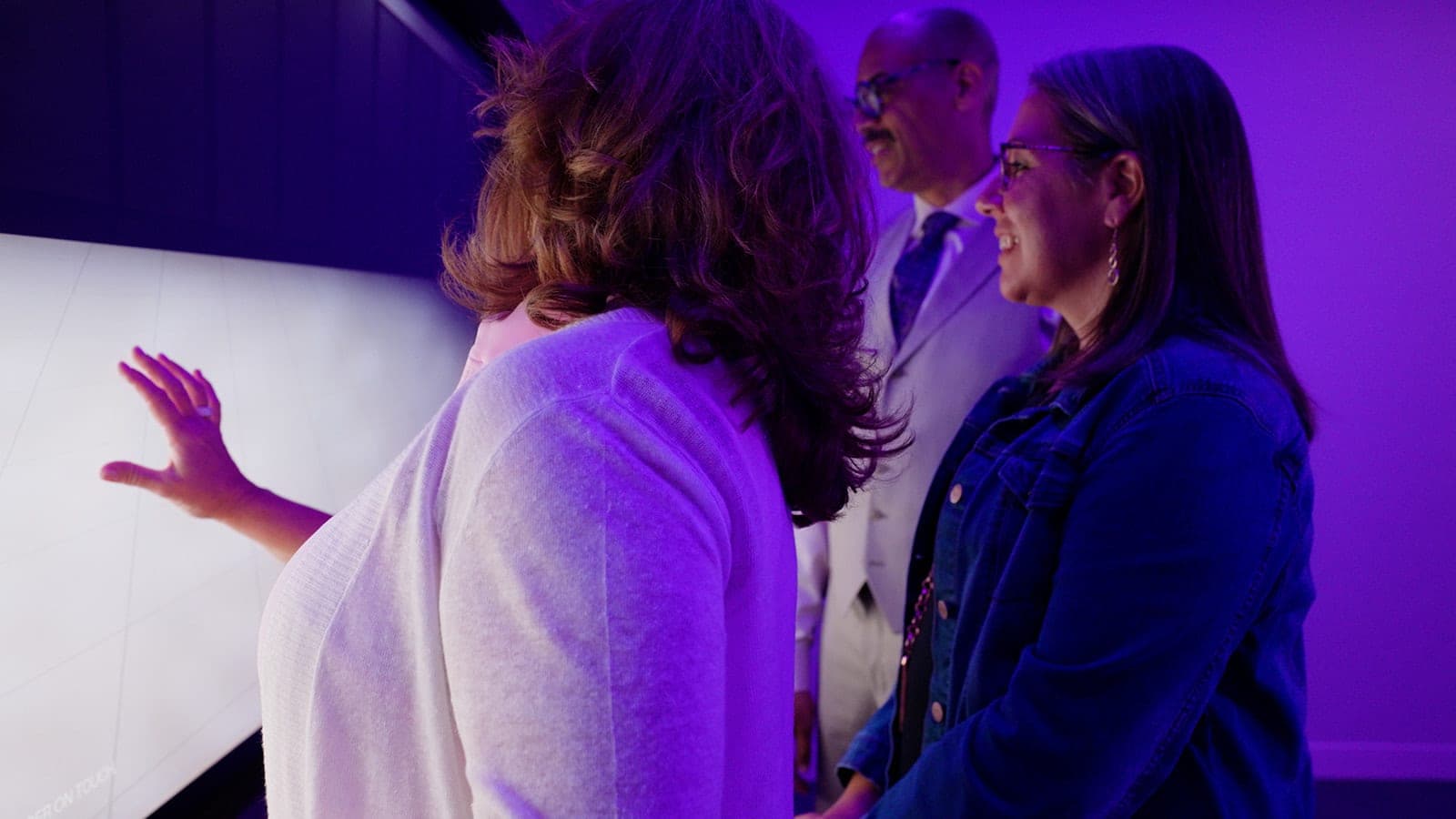 A frame from the Belden brand film: colleagues gathered at the interactive touch table mid-conversation, cinematic corporate video produced in St. Louis