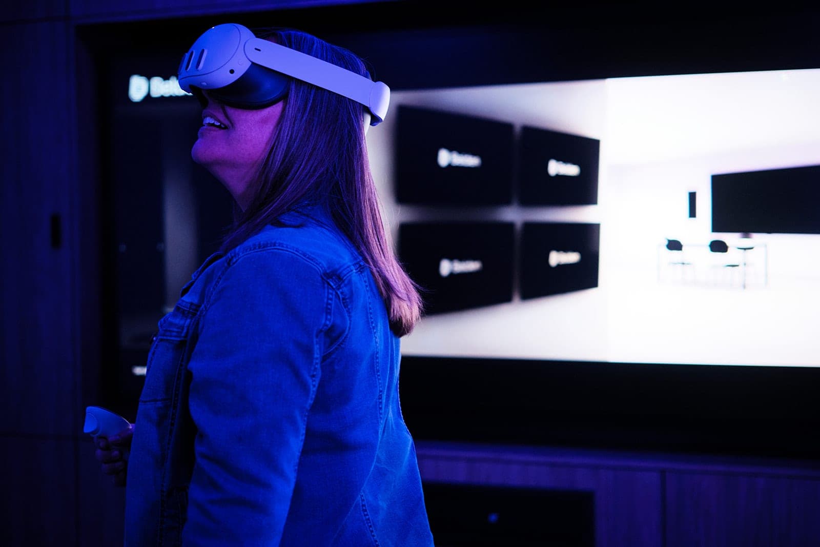 A VR headset session in the Belden validation lab in front of a wall screen showing a rendered room layout, workplace technology photography in St. Louis
