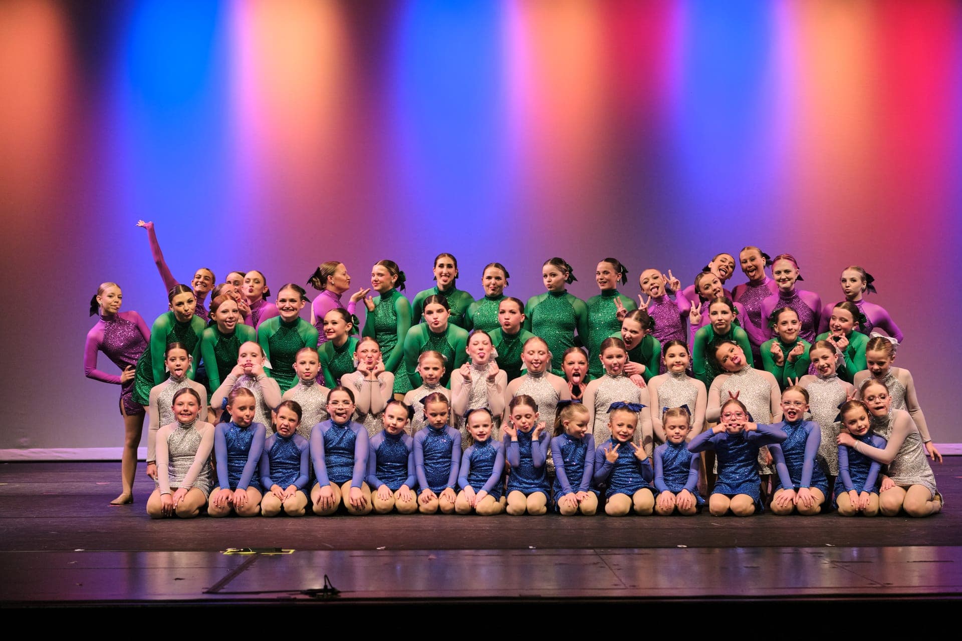 Full dance studio cast gathered on a St. Louis recital stage in costume