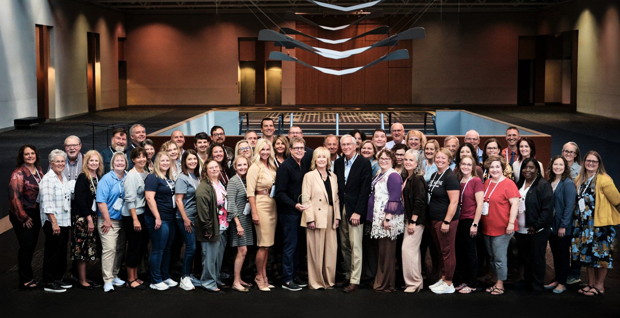 Group photograph of attendees at a business and public-affairs program in a St. Louis convention center