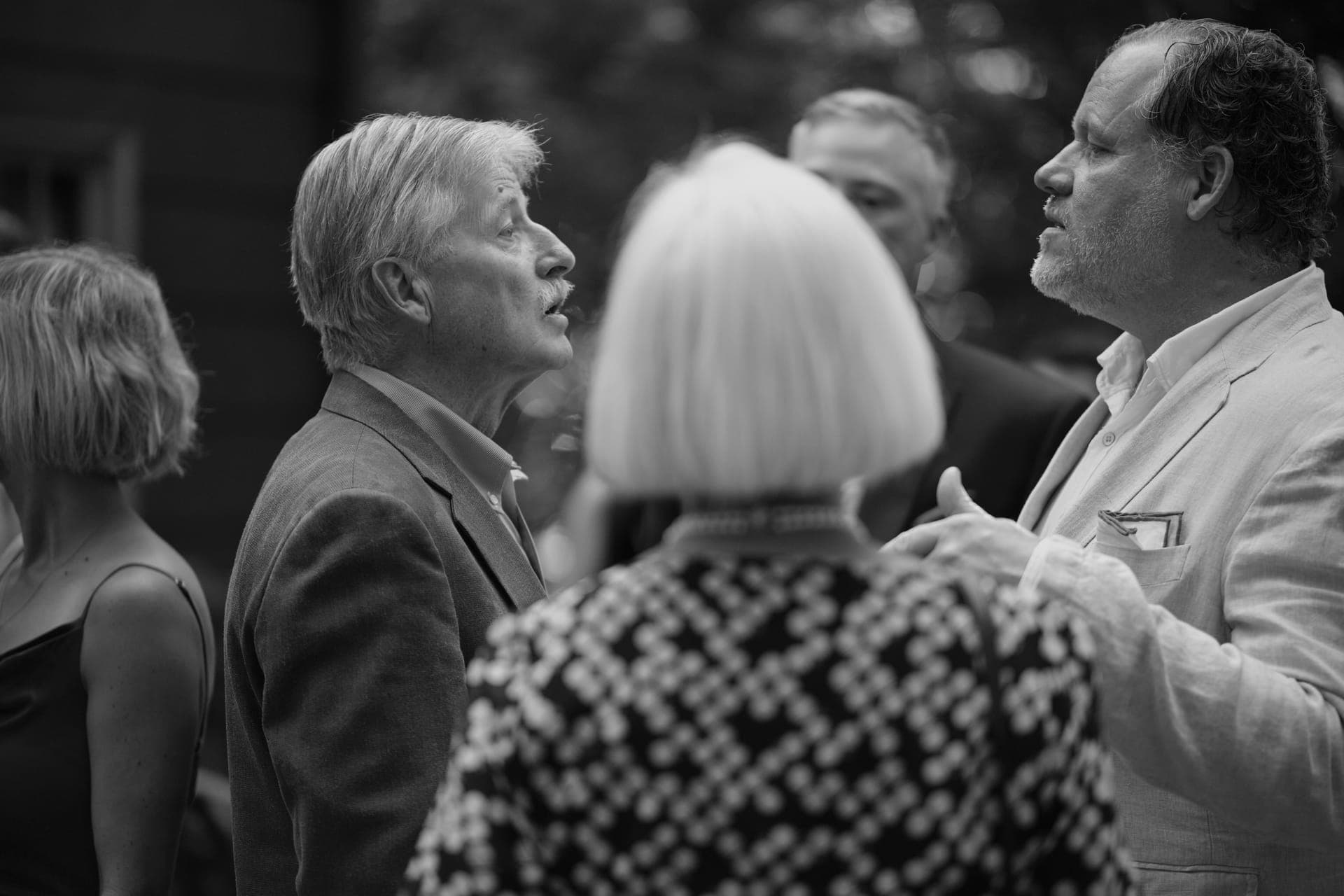 Black and white photo of three relatives in animated conversation at a family reunion at Deer Creek Club in Ladue