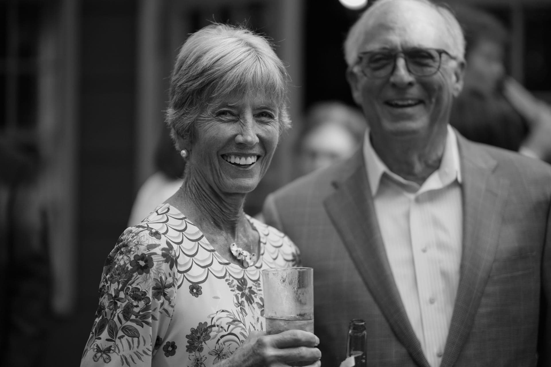 Black and white photo of a woman laughing beside a smiling man at a family reunion in Ladue