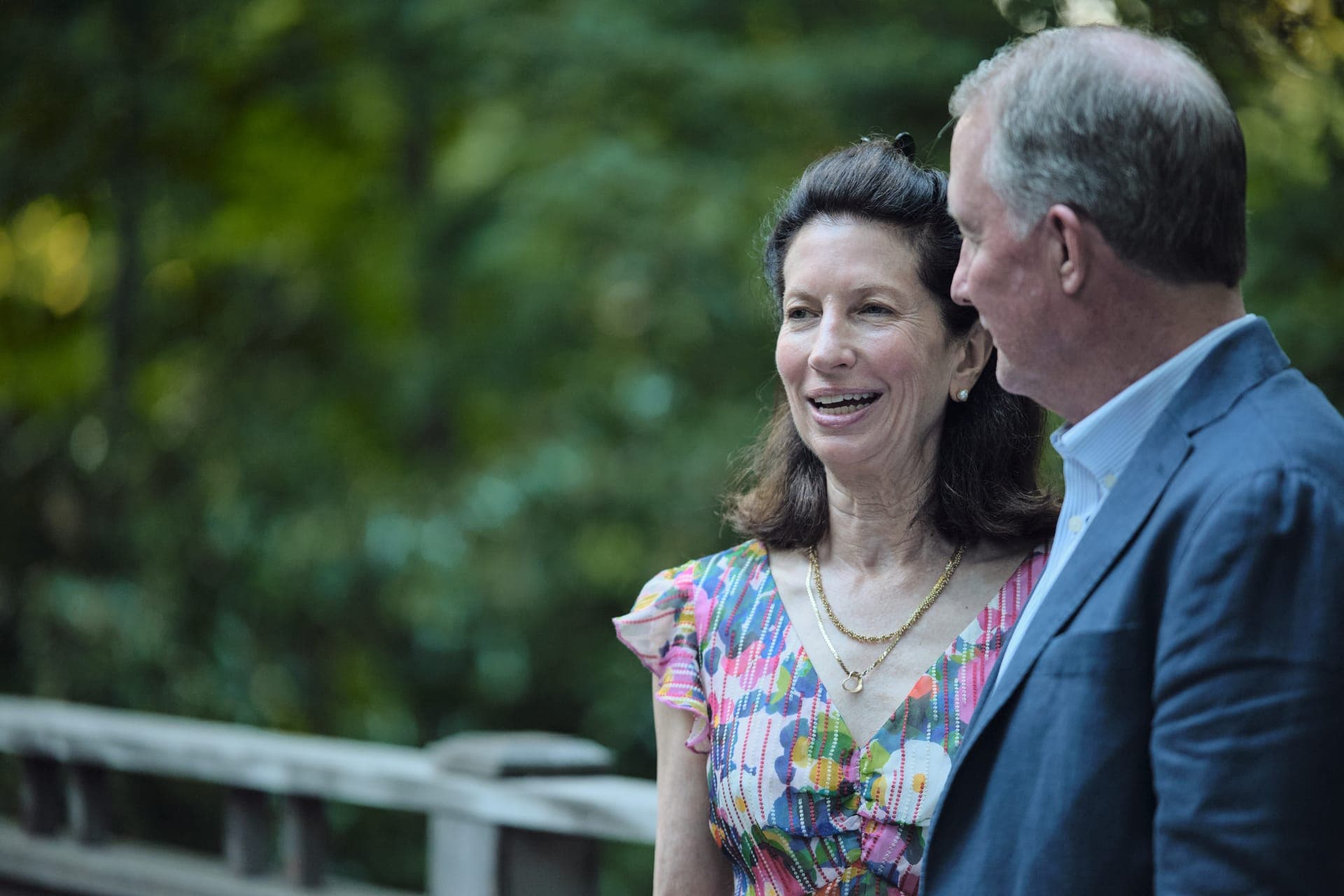 A woman looks up at her partner with a warm smile at a family reunion in Ladue