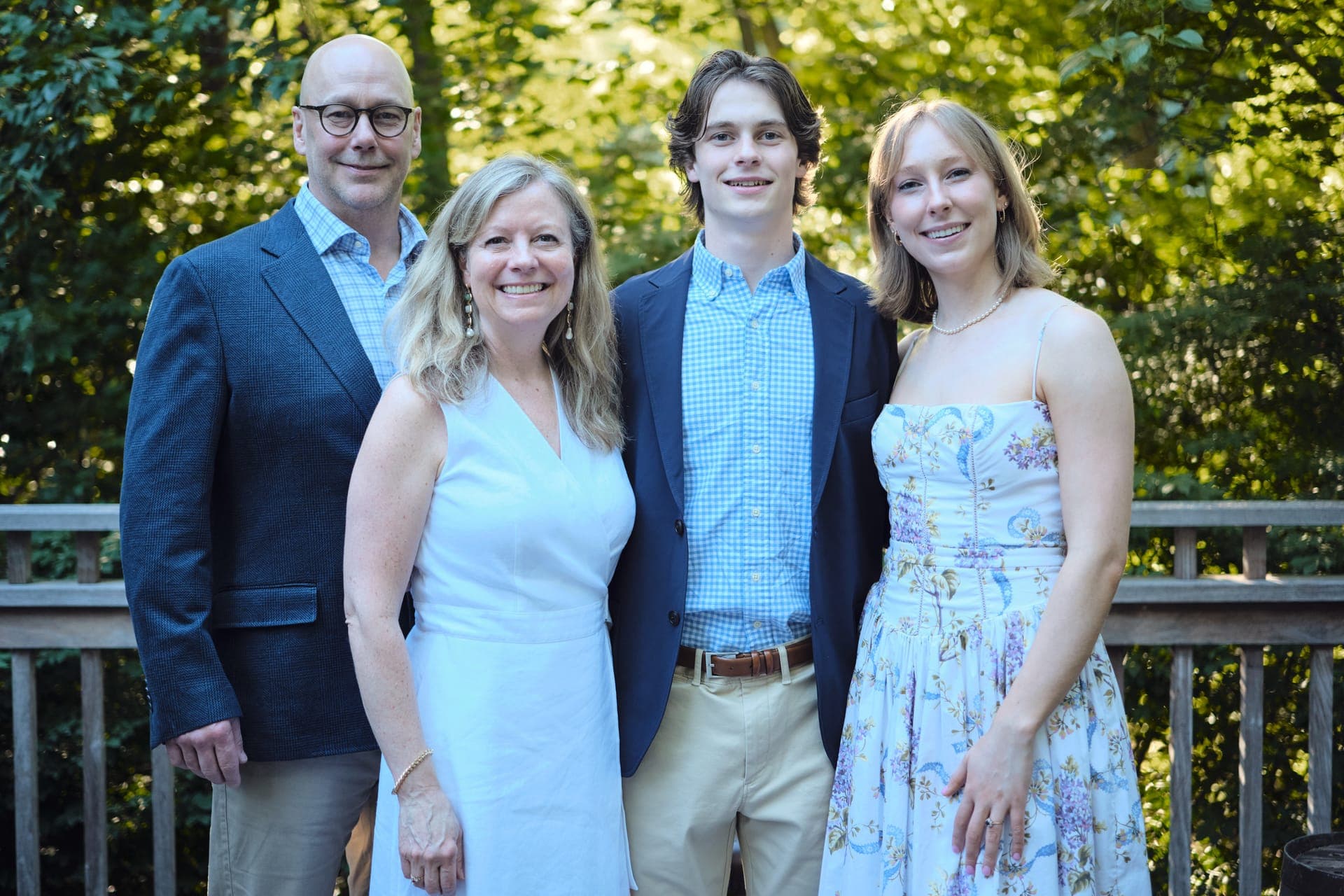 A family of four smiles together for a golden hour portrait at Deer Creek Club in Ladue