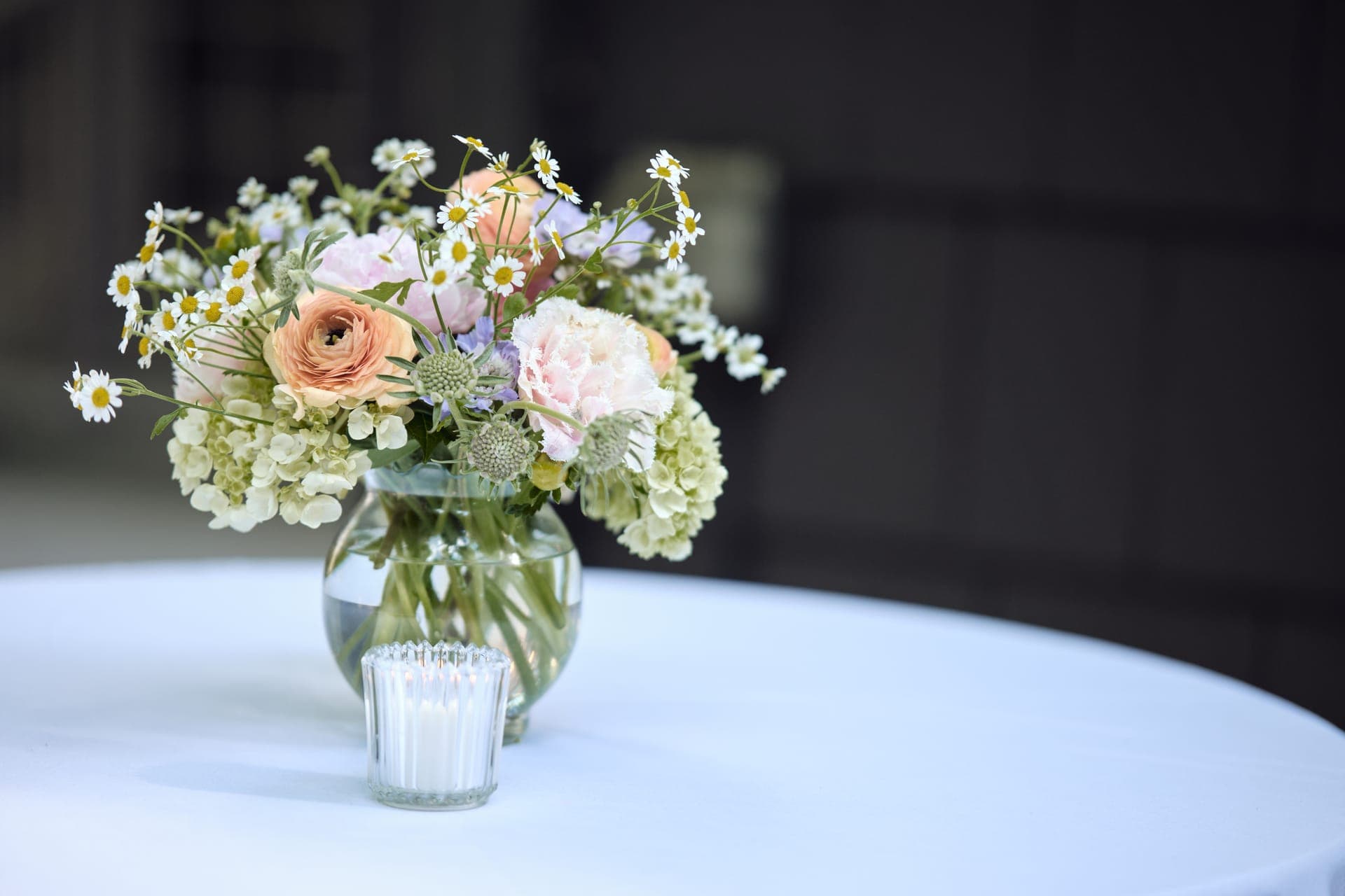 A floral centerpiece and candle on a cocktail table at a family reunion at Deer Creek Club