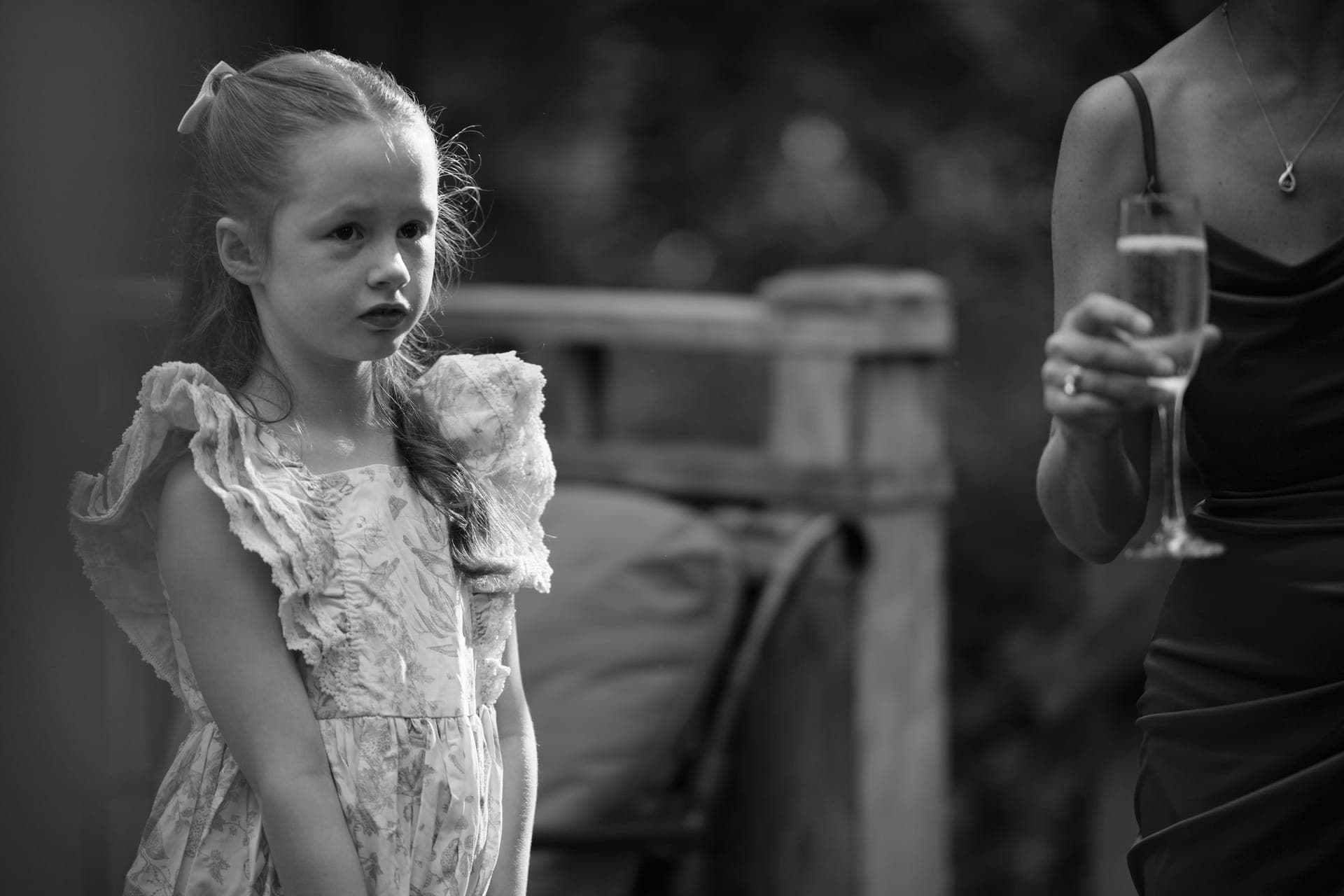Black and white photo of a girl in lace beside a champagne glass at a family reunion at Deer Creek Club