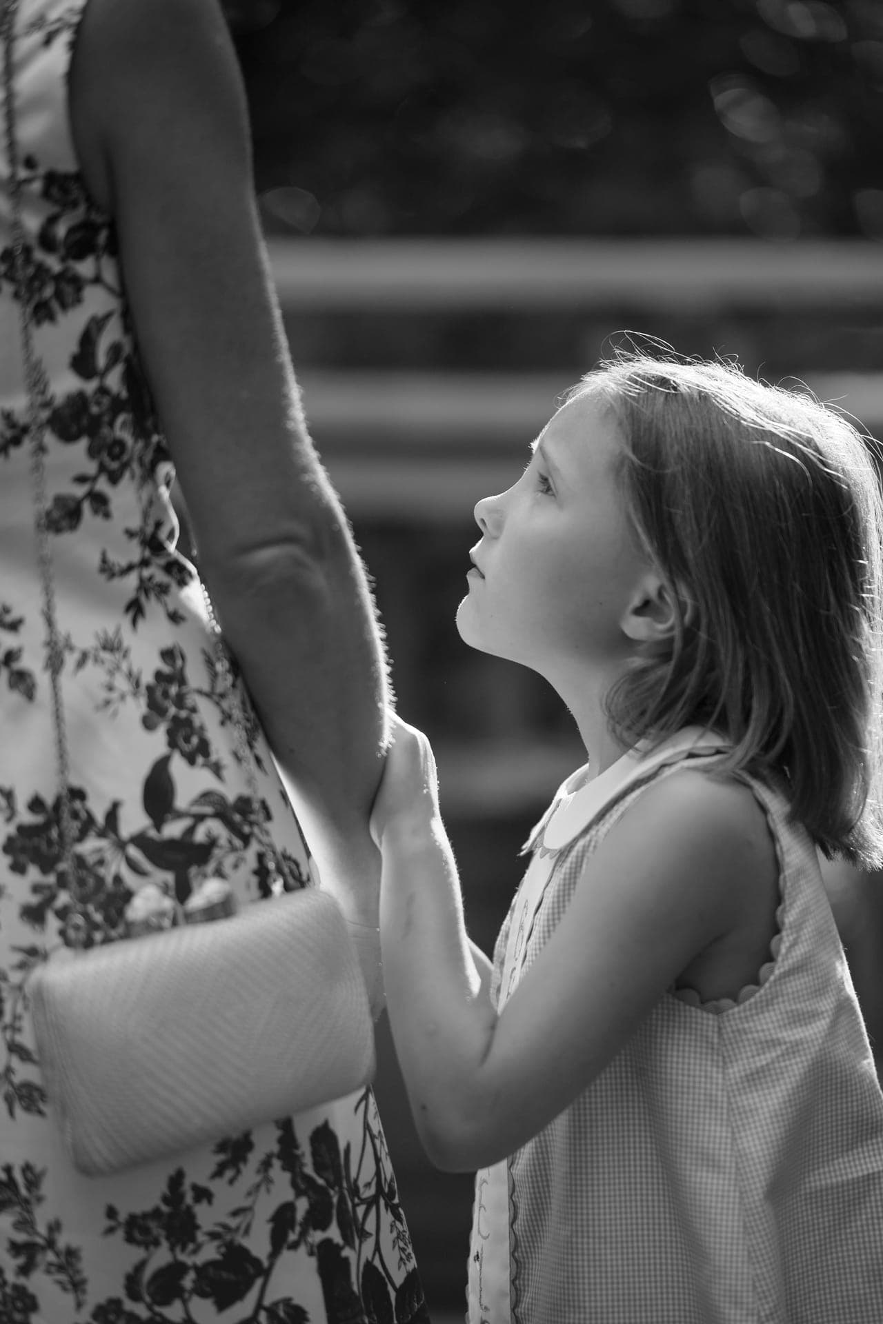 Black and white photo of a girl holding her mother's hand at a family reunion at Deer Creek Club