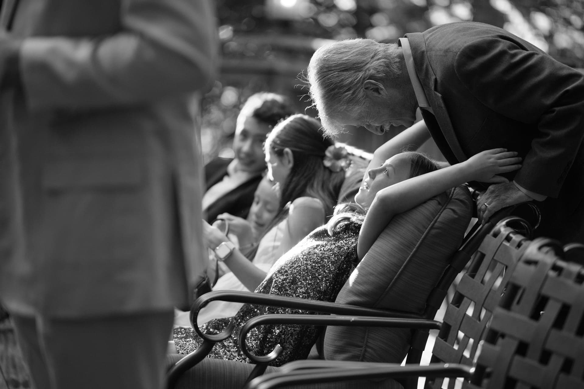 Black and white photo of a grandfather cupping his granddaughter's face at a family reunion in Ladue