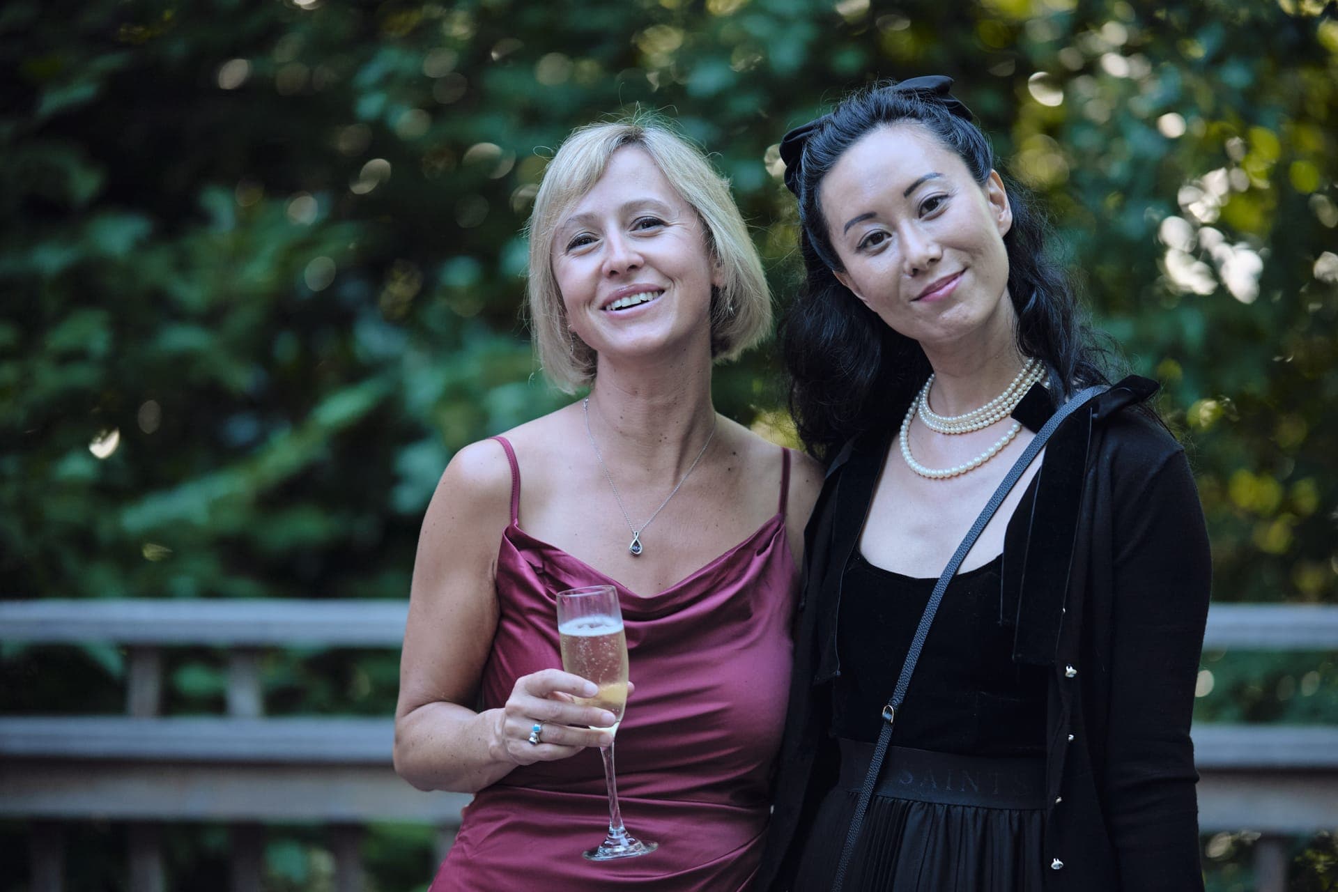 Two friends pose together in golden evening light at a family reunion in Ladue