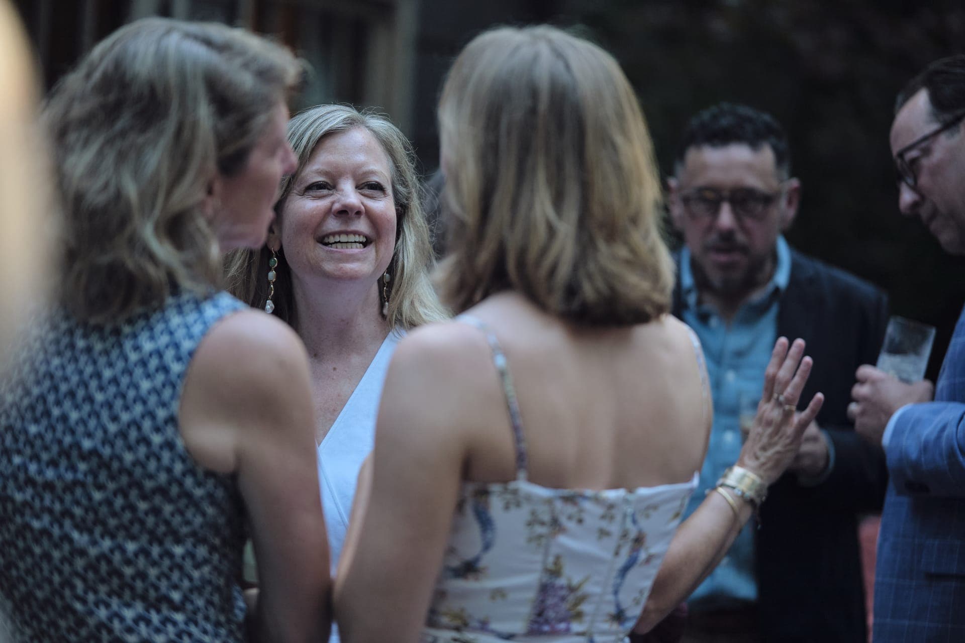 A woman laughs during cocktail hour at a family reunion at Deer Creek Club in Ladue