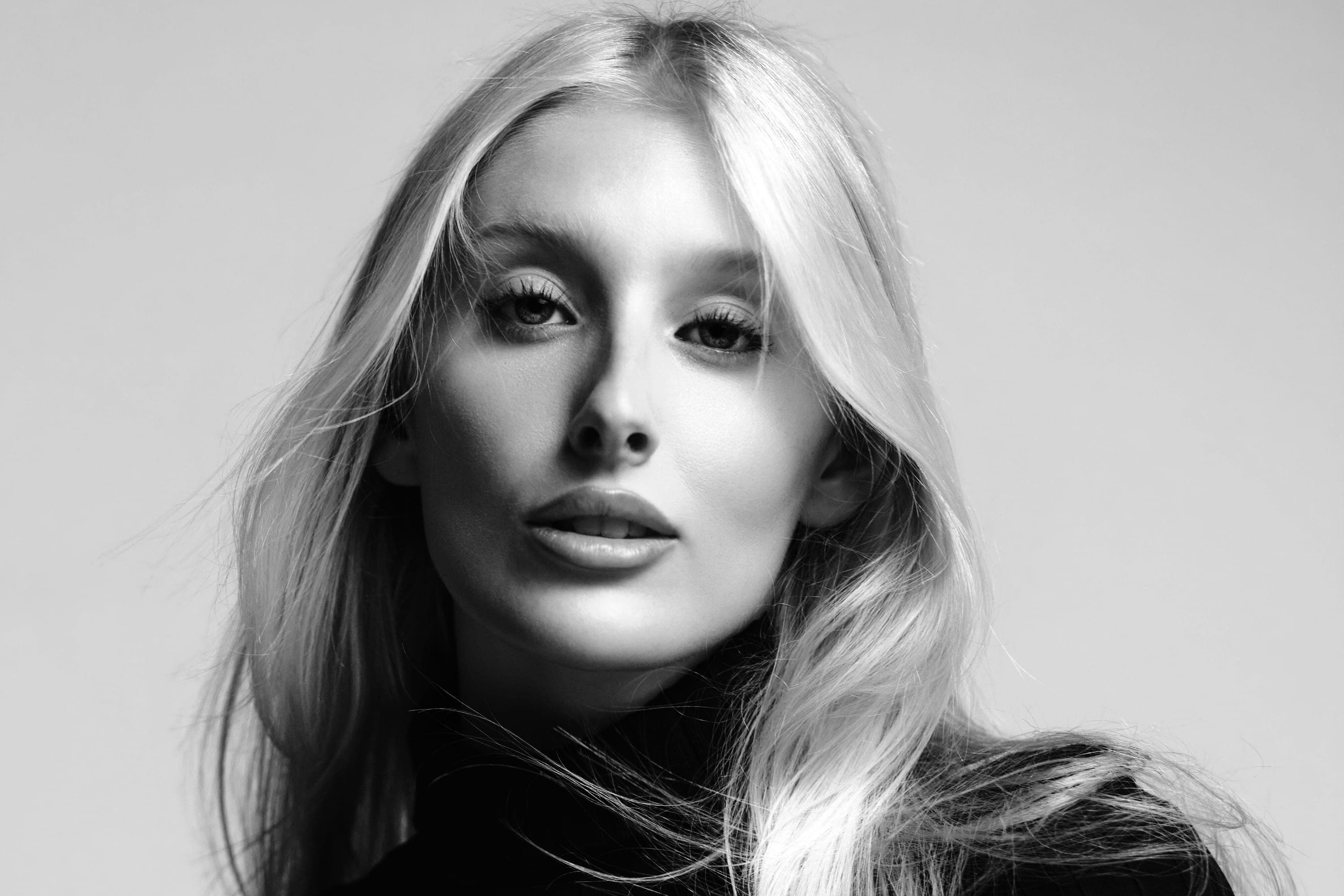 Elizabeth Nichole Jones in a black rib-knit turtleneck, hair over one shoulder, close, black and white