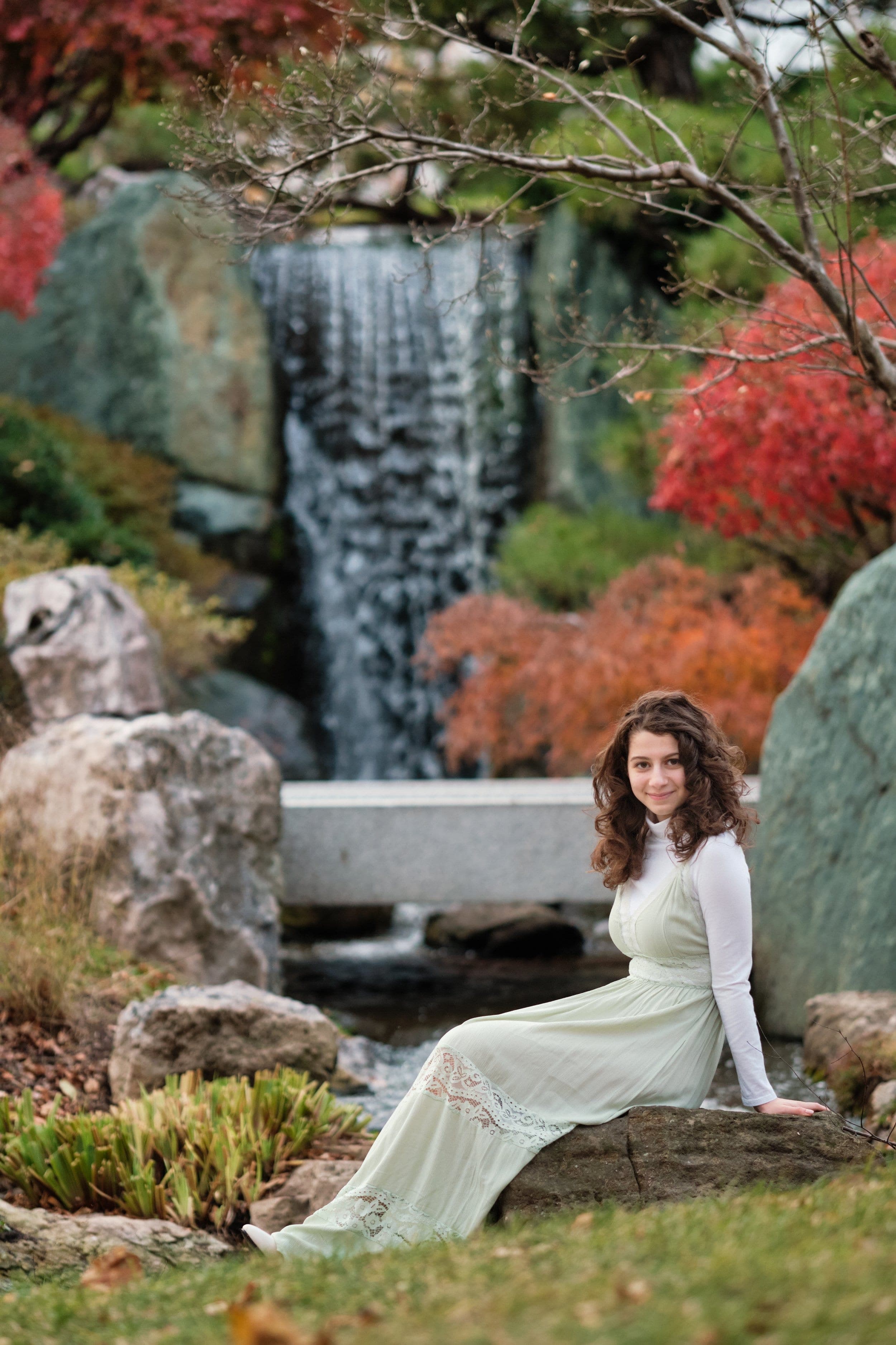 Outdoor portrait of a young woman in a white dress by a garden waterfall by Henry David Photography, the standard every Kirkwood headshot session is held to