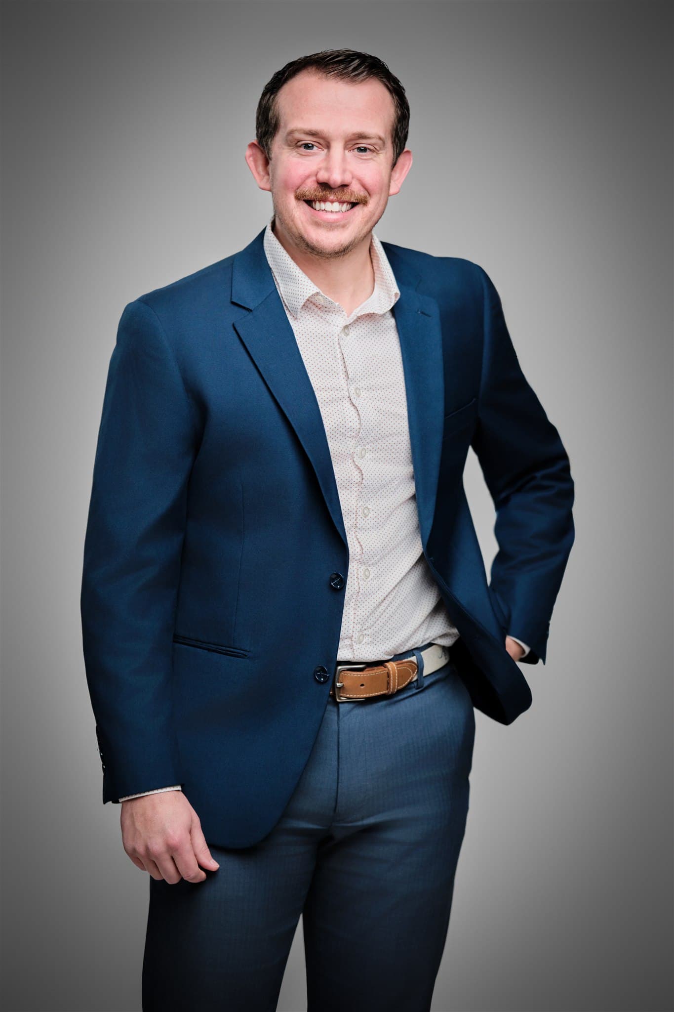 Justin Bocek corporate portrait in suit jacket lit with precision studio strobes on a neutral backdrop, demonstrating the lighting precision used on product work