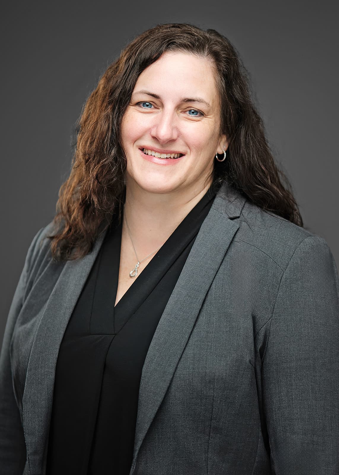Caren Puvalowski RubinBrown partner headshot in tailored dark blazer on neutral backdrop with three-point studio lighting, photographed at the Centene Building in Clayton