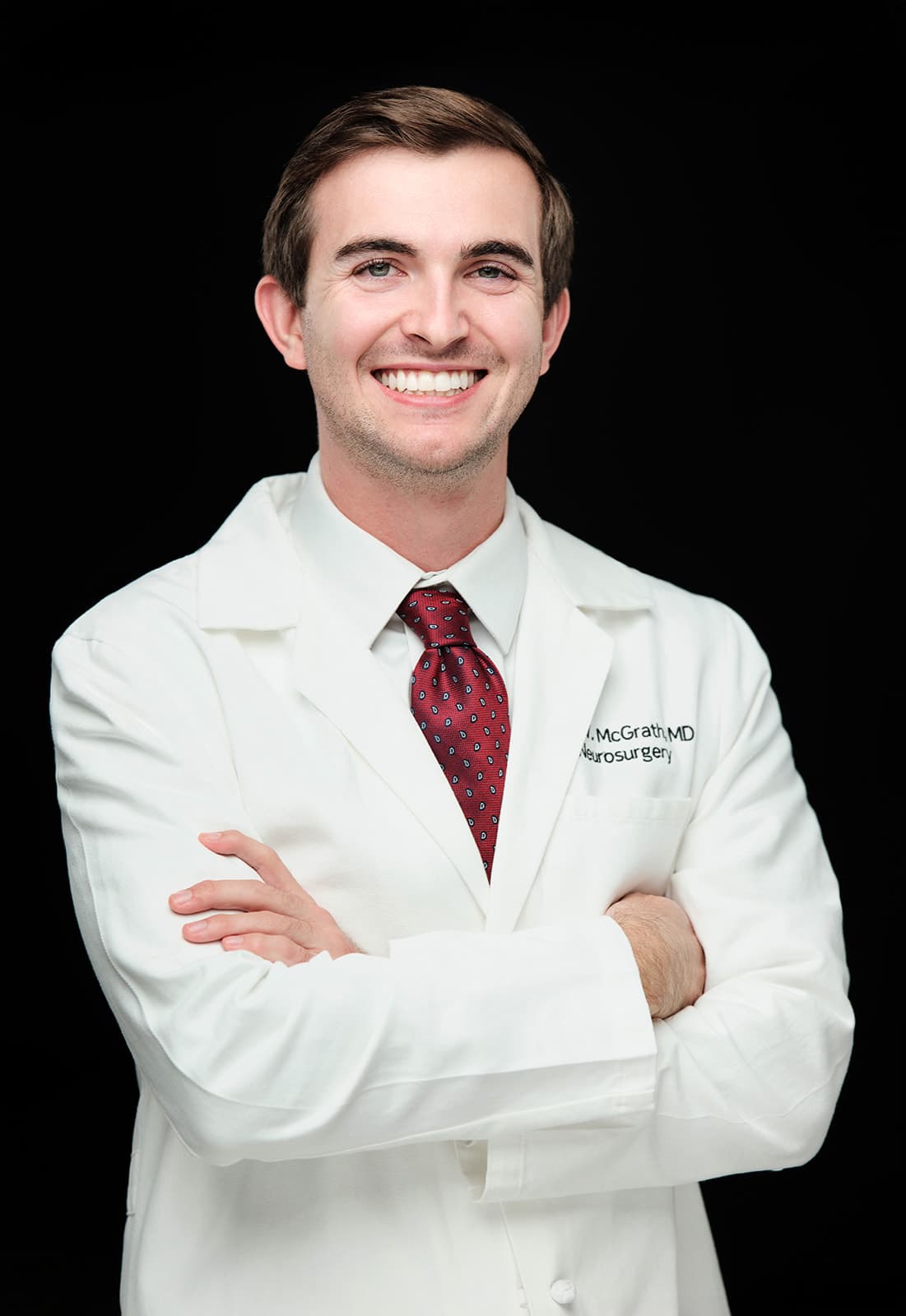 Dr. Kyle McGrath, WashU Neurosurgery, white coat headshot on black backdrop by Henry David Photography