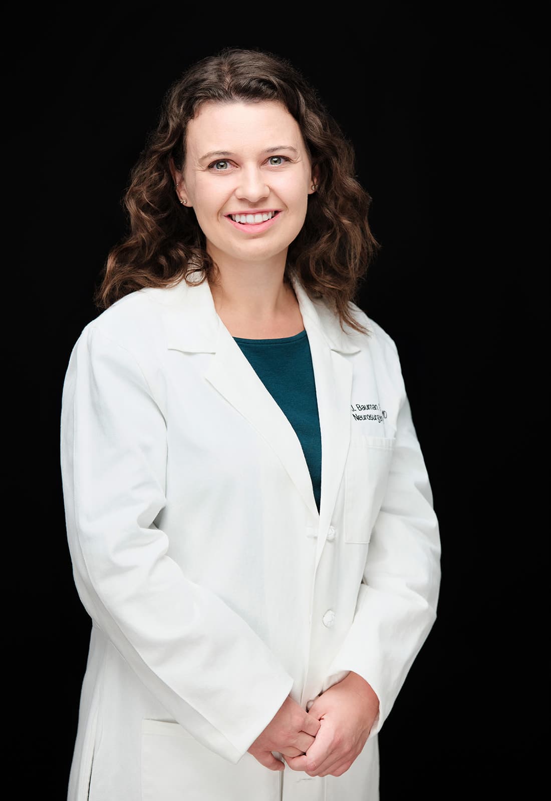 Dr. Megan Bauman Graves, WashU Neurosurgery, white coat headshot on black backdrop by Henry David Photography