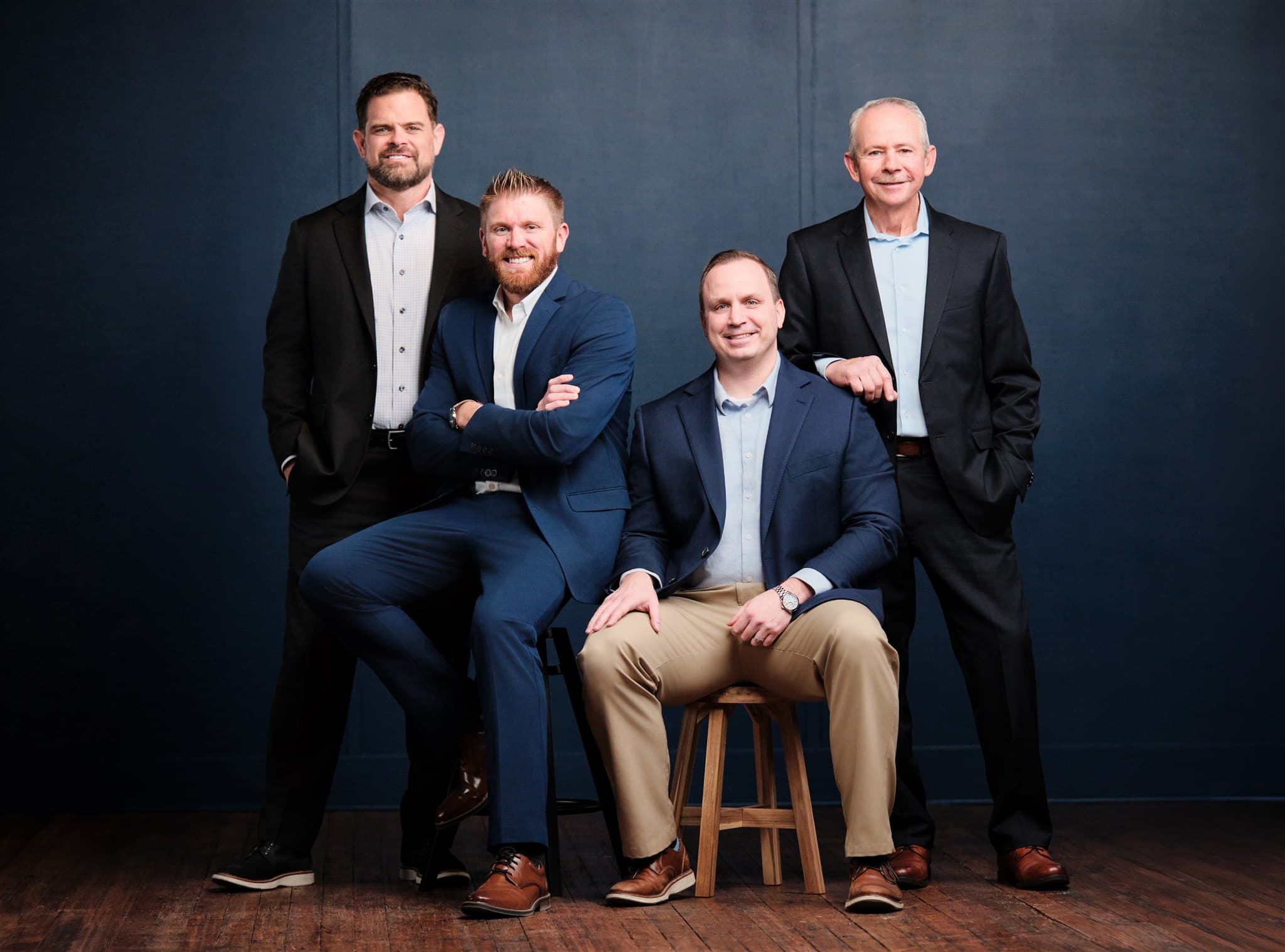 MHS Legacy executive team group portrait of four leaders photographed in a cohesive studio setting by Henry David Photography