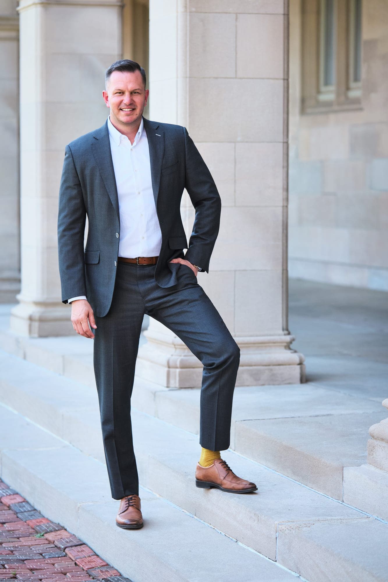 Environmental executive portrait in a grey suit on location, matched to the program's visual standard