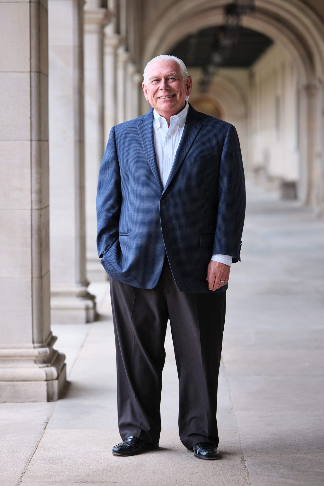 Leadership headshot in a navy blazer with consistent lighting and framing for a corporate headshot program