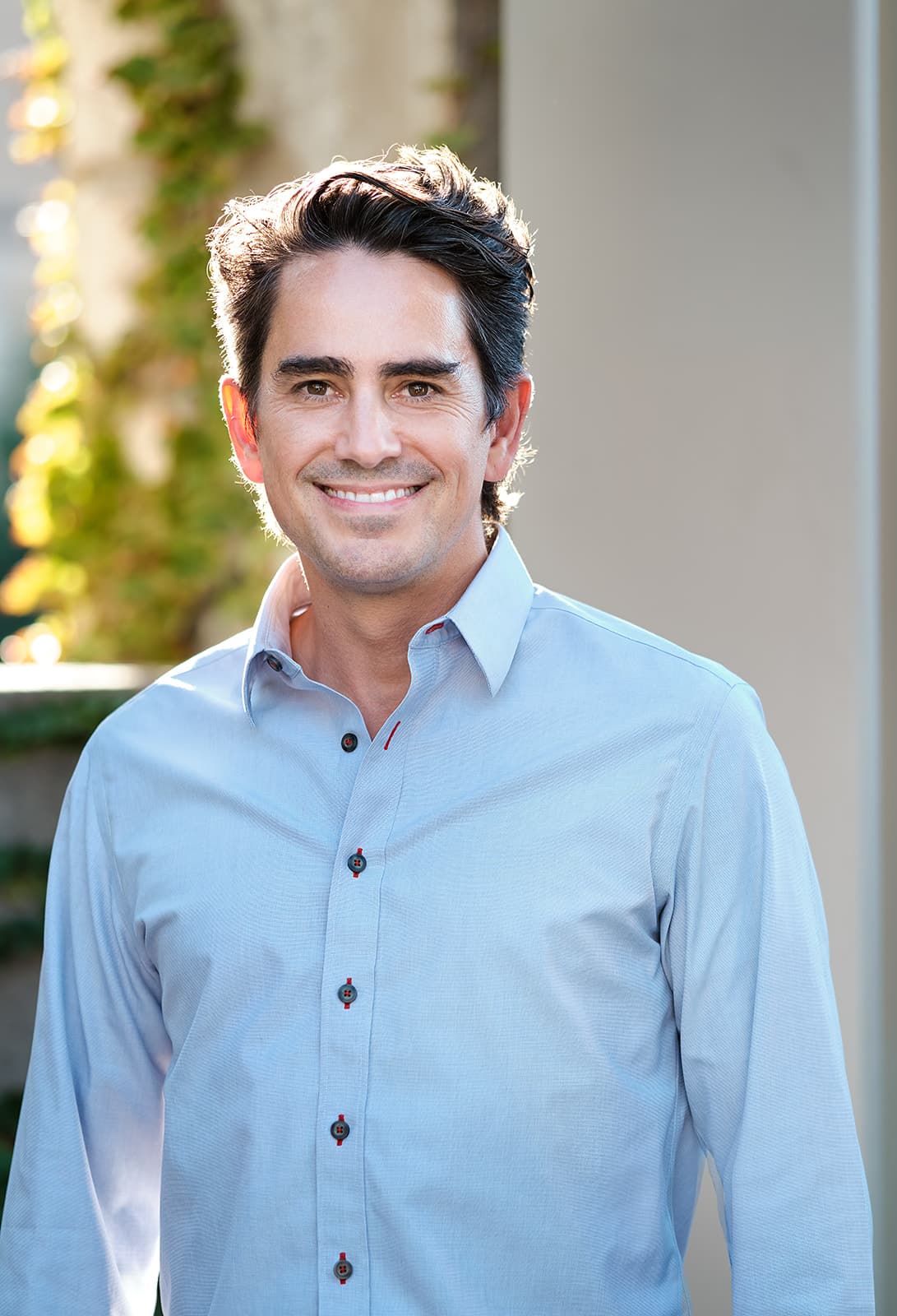 Walker Deibel candid portrait in a checked shirt against natural trees, used for lifestyle content