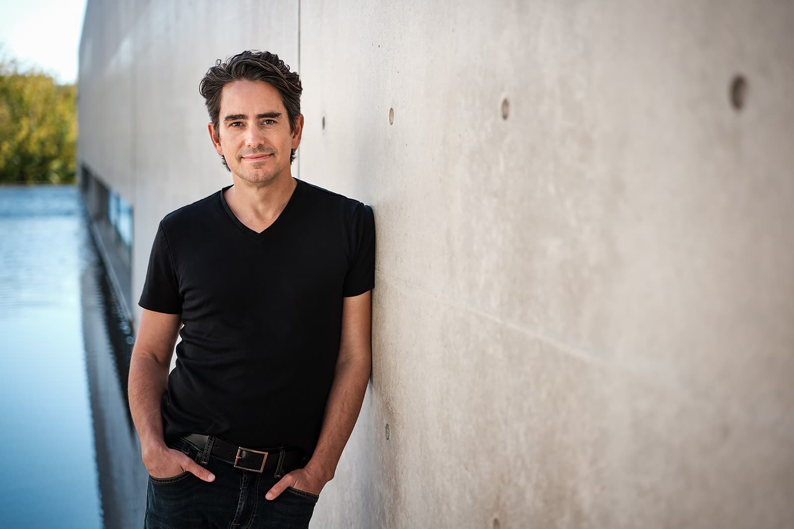Walker Deibel entrepreneur portrait leaning against concrete wall in St. Louis by Henry David Photography