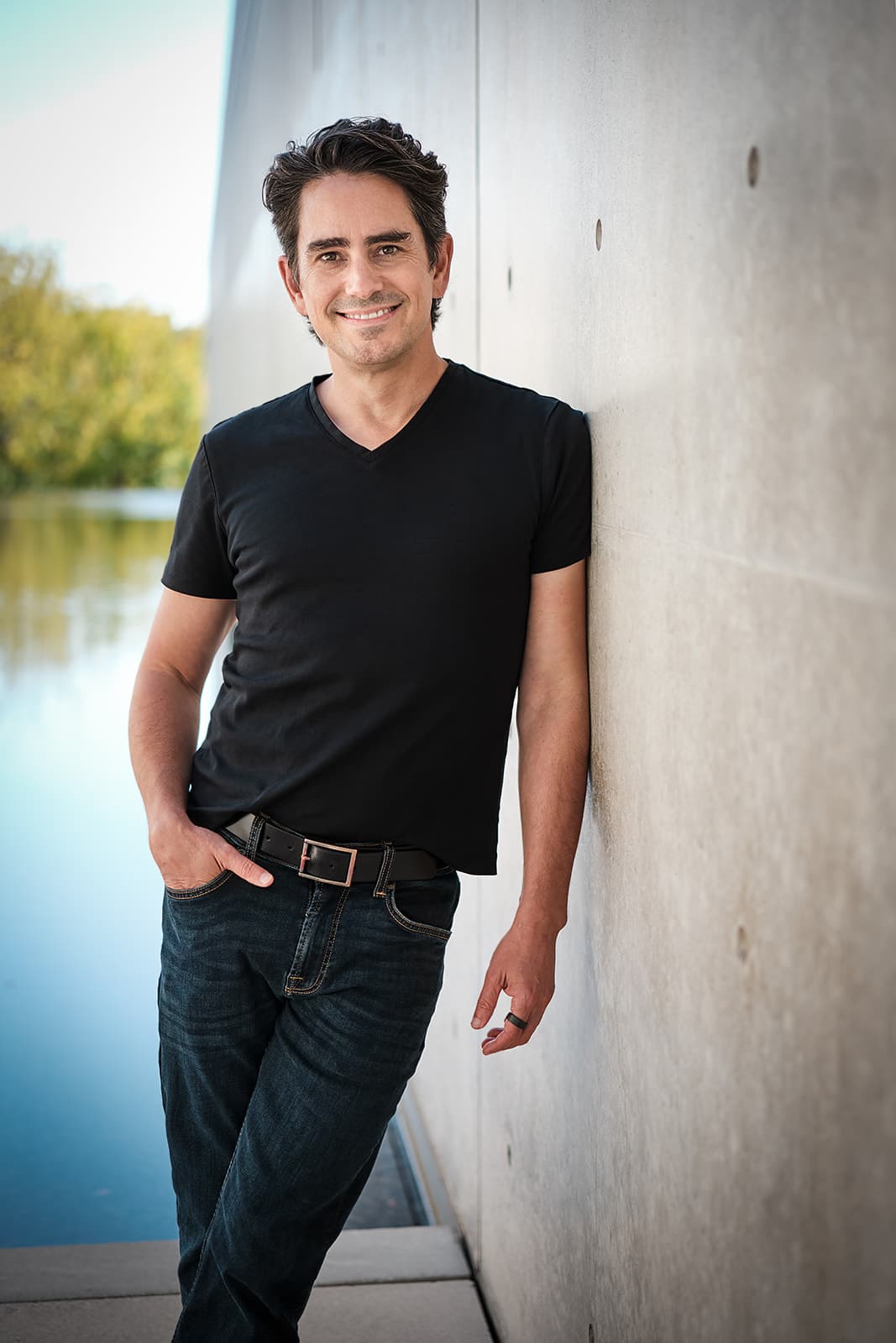 Walker Deibel in black V-neck at the Pulitzer Arts Foundation in St. Louis, Tadao Ando concrete wall and reflecting pool in frame, used for distinctive editorial branding