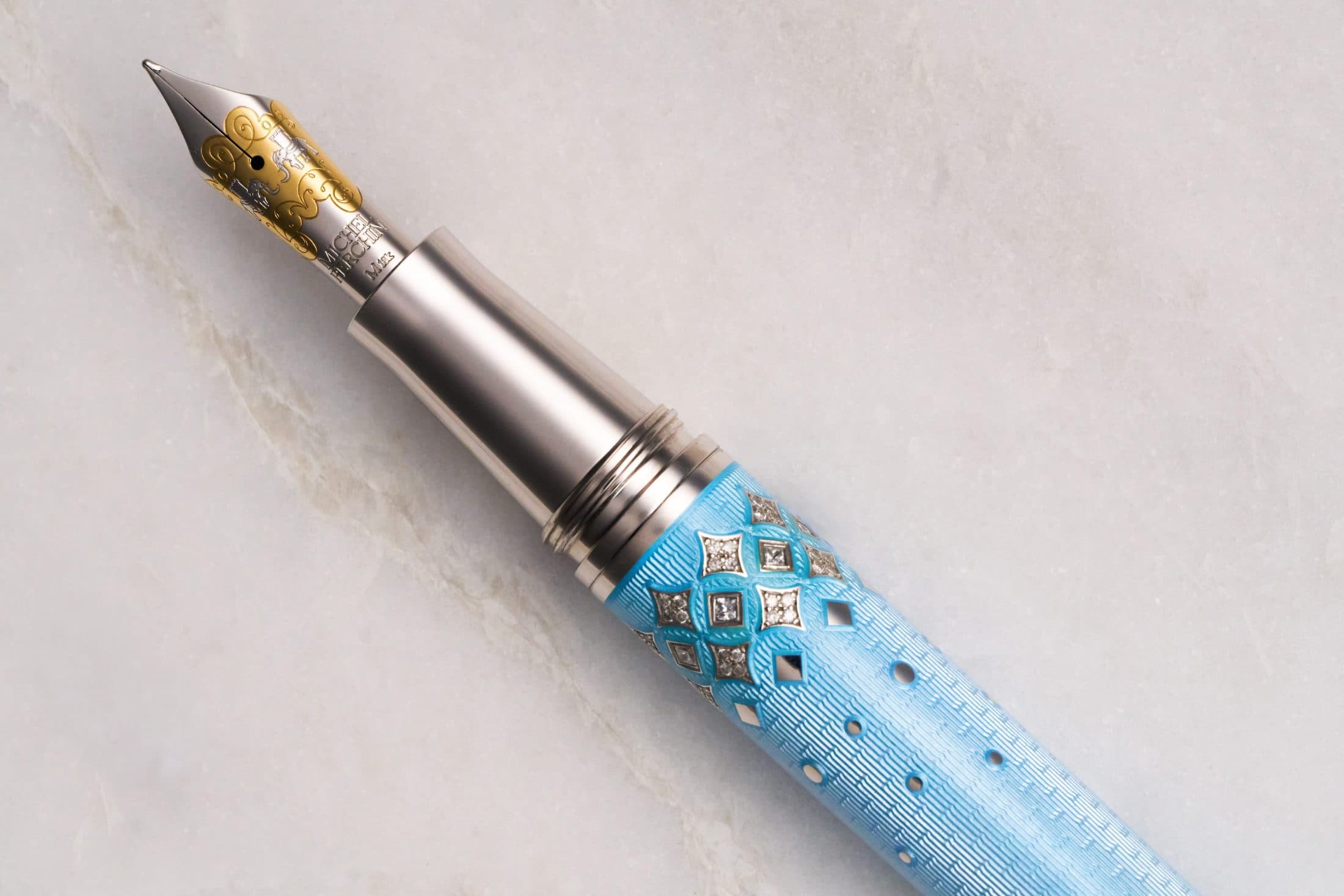 Michel Perchin Majesty blue guilloche enamel fountain pen reclined, diamond-set clip, on Carrara marble