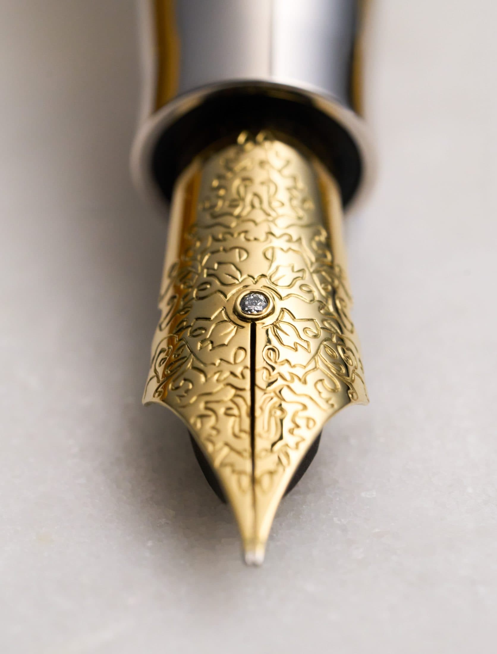 Macro of a Michel Perchin Majesty gilt fountain pen nib set with a diamond and fine hand engraving