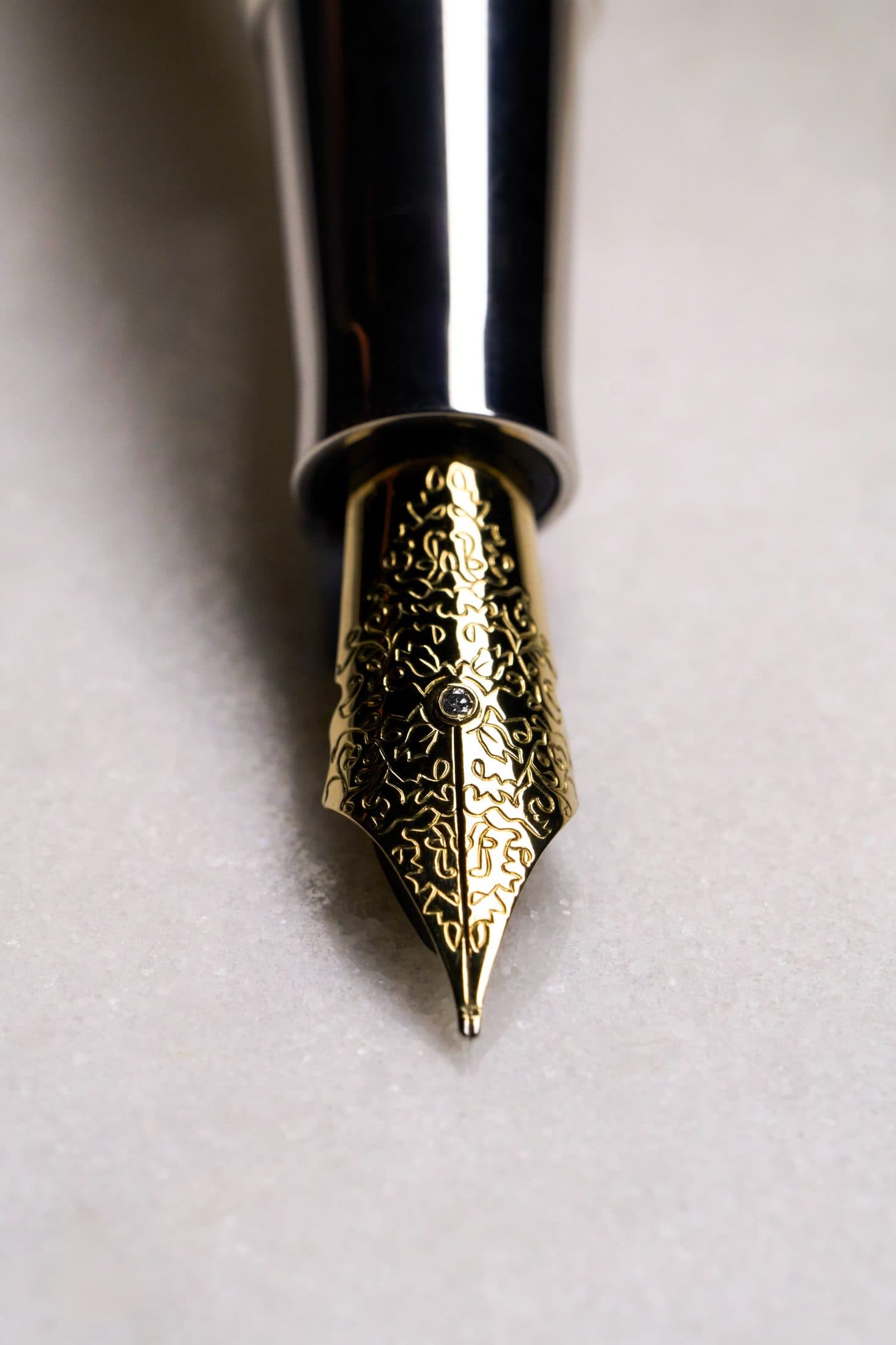 Macro of a Michel Perchin Majesty gilt fountain pen nib against a black ground