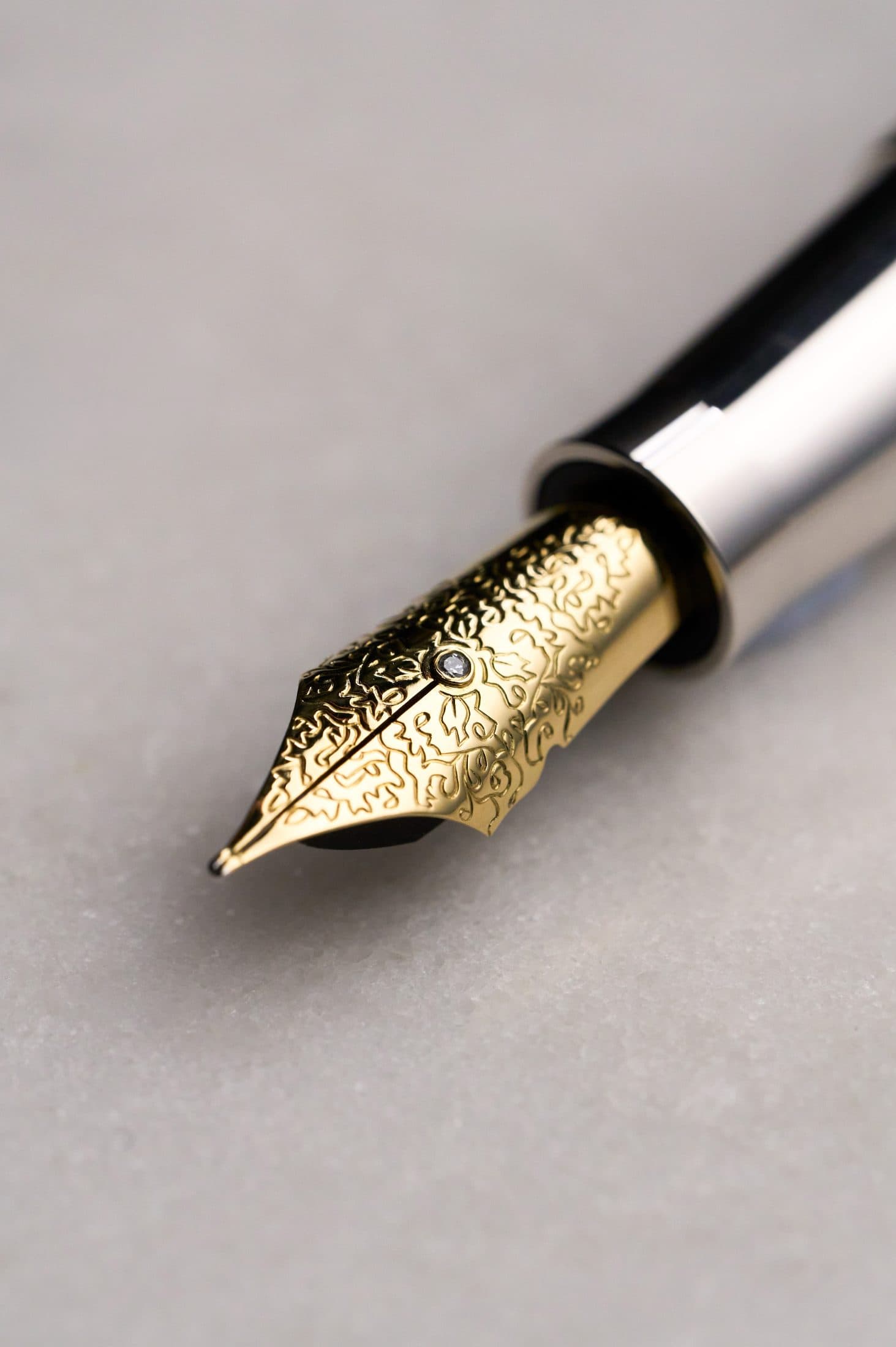 Macro of a Michel Perchin Majesty bicolour fountain pen nib against a black ground
