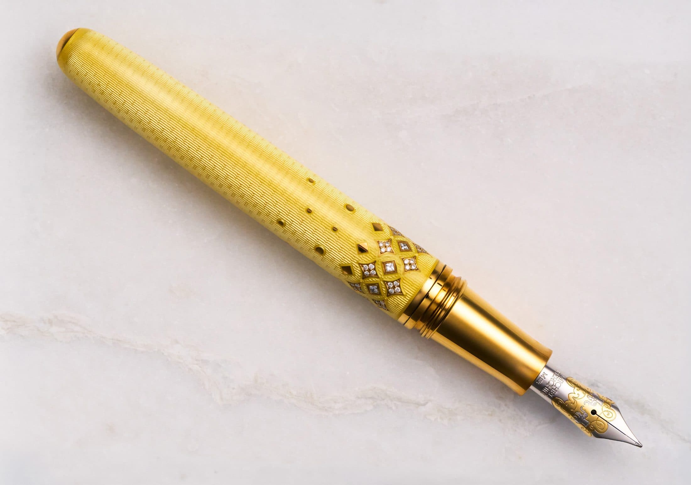 Michel Perchin Majesty yellow guilloche enamel fountain pen reclined on Carrara marble