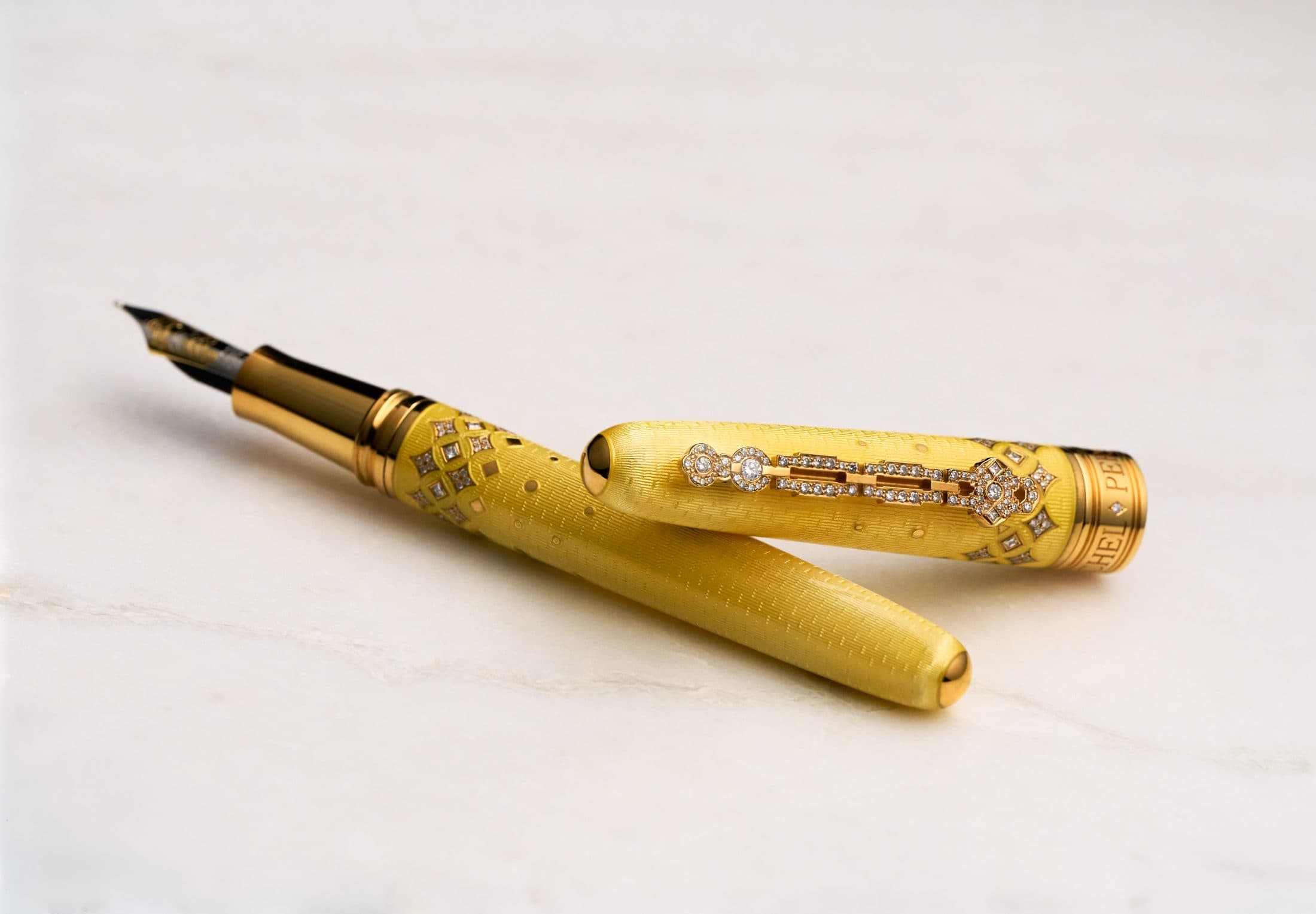 Michel Perchin Majesty yellow guilloche enamel fountain pen with cap and barrel parted on Carrara marble