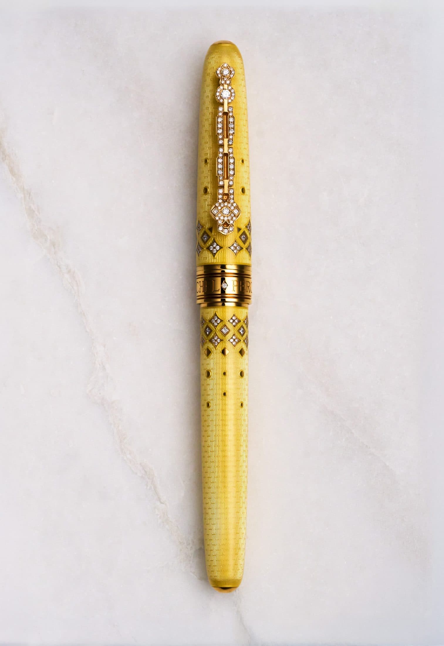 Michel Perchin Majesty yellow guilloche enamel fountain pen with diamond-set clip, full length on Carrara marble