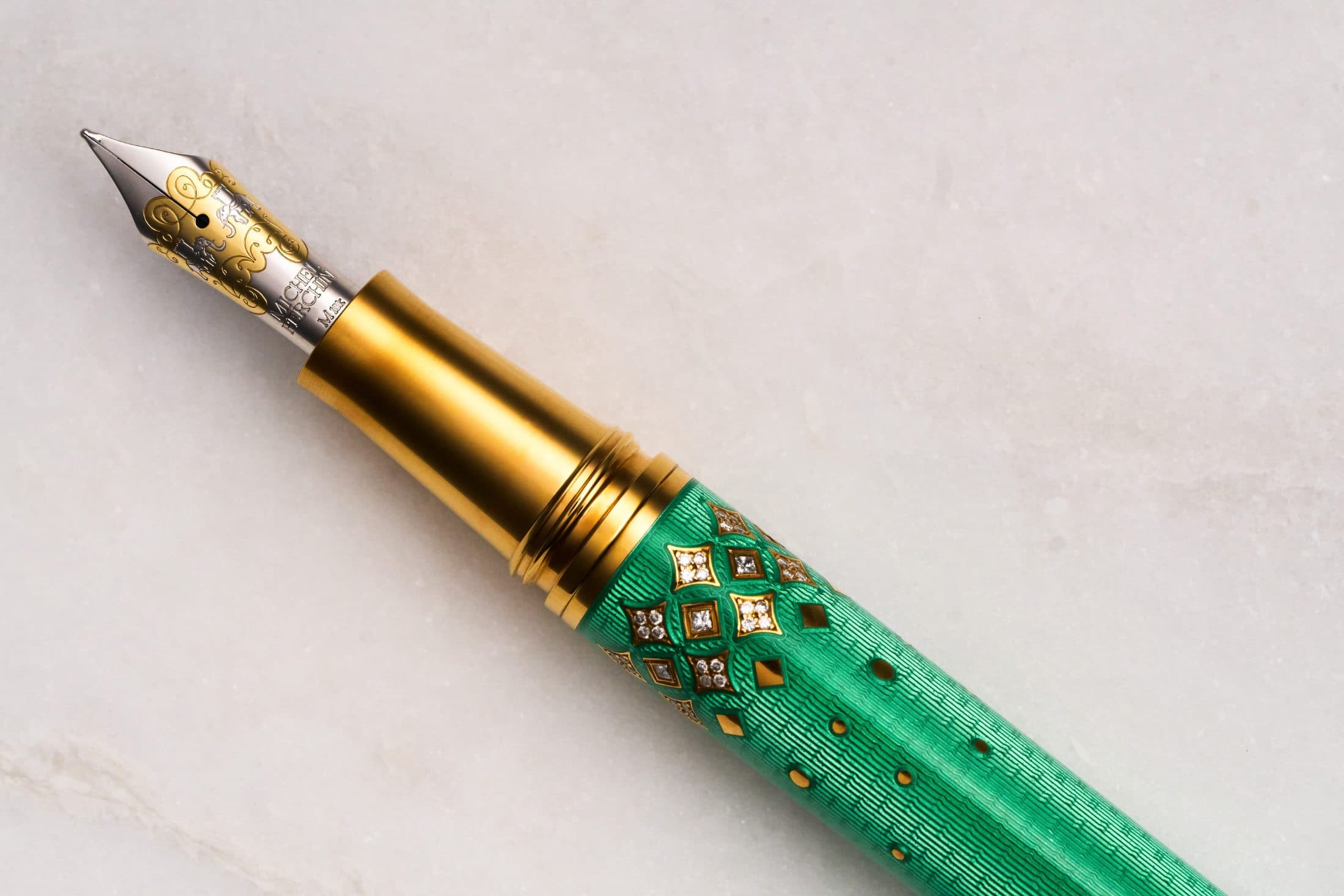 Michel Perchin Majesty green fountain pen with a two-tone gilt nib, macro on Carrara marble