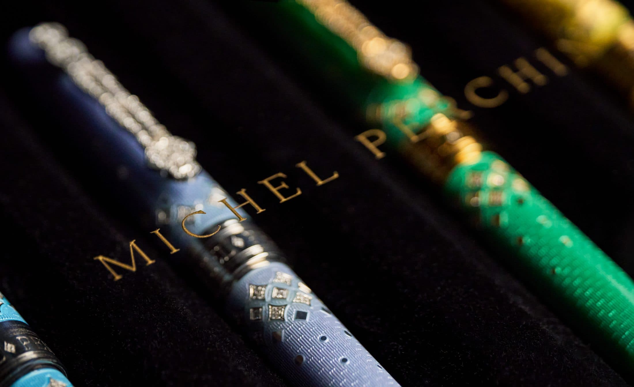 Michel Perchin Majesty fountain pens resting in dark velvet beneath the gold-leaf house signature, macro photograph by Henry David Photography