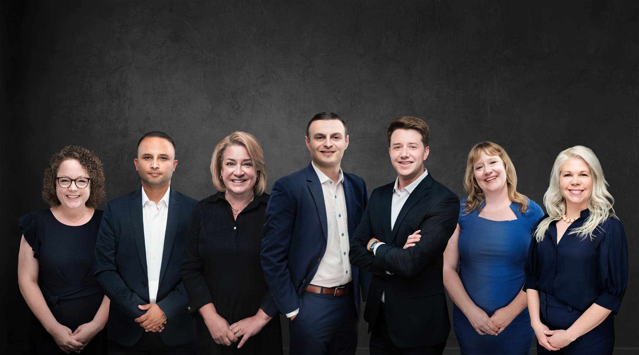 Phase Financial team composite with seven people on the same textured charcoal background, Northwestern Mutual, Clayton, by Henry David Photography