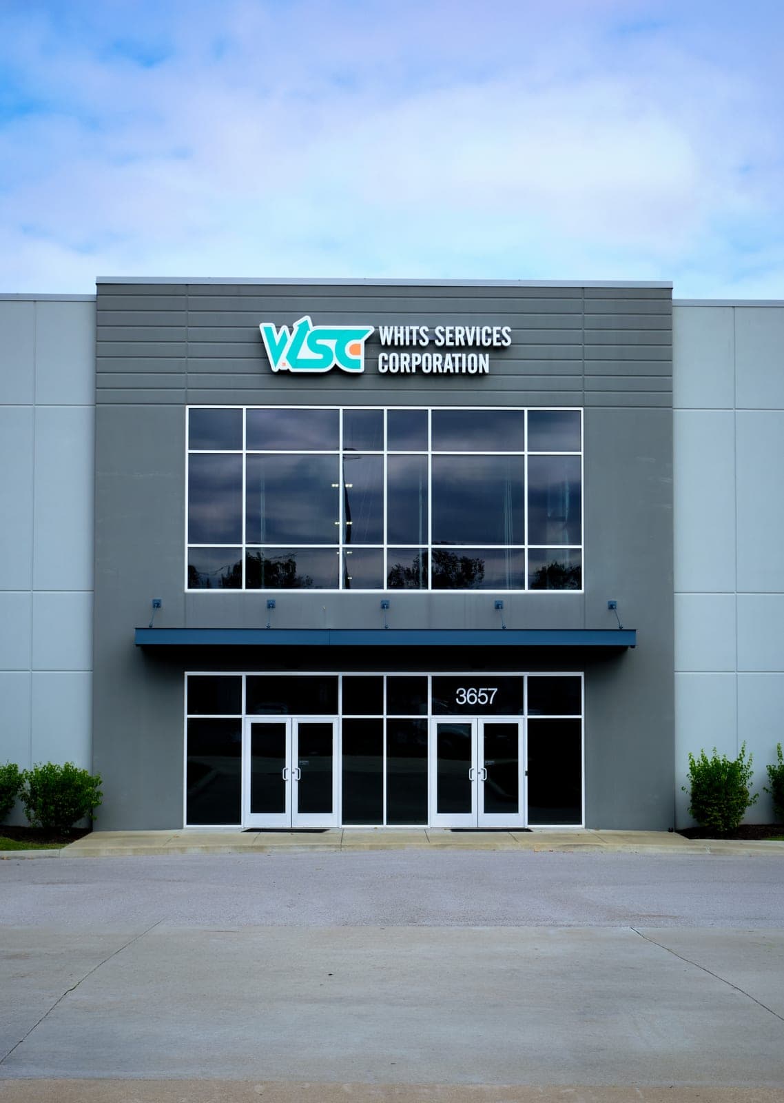 Straight-on view of the WSC Whits Services Corporation front entrance and sign under an overcast sky, Bridgeton, Missouri, near St. Louis
