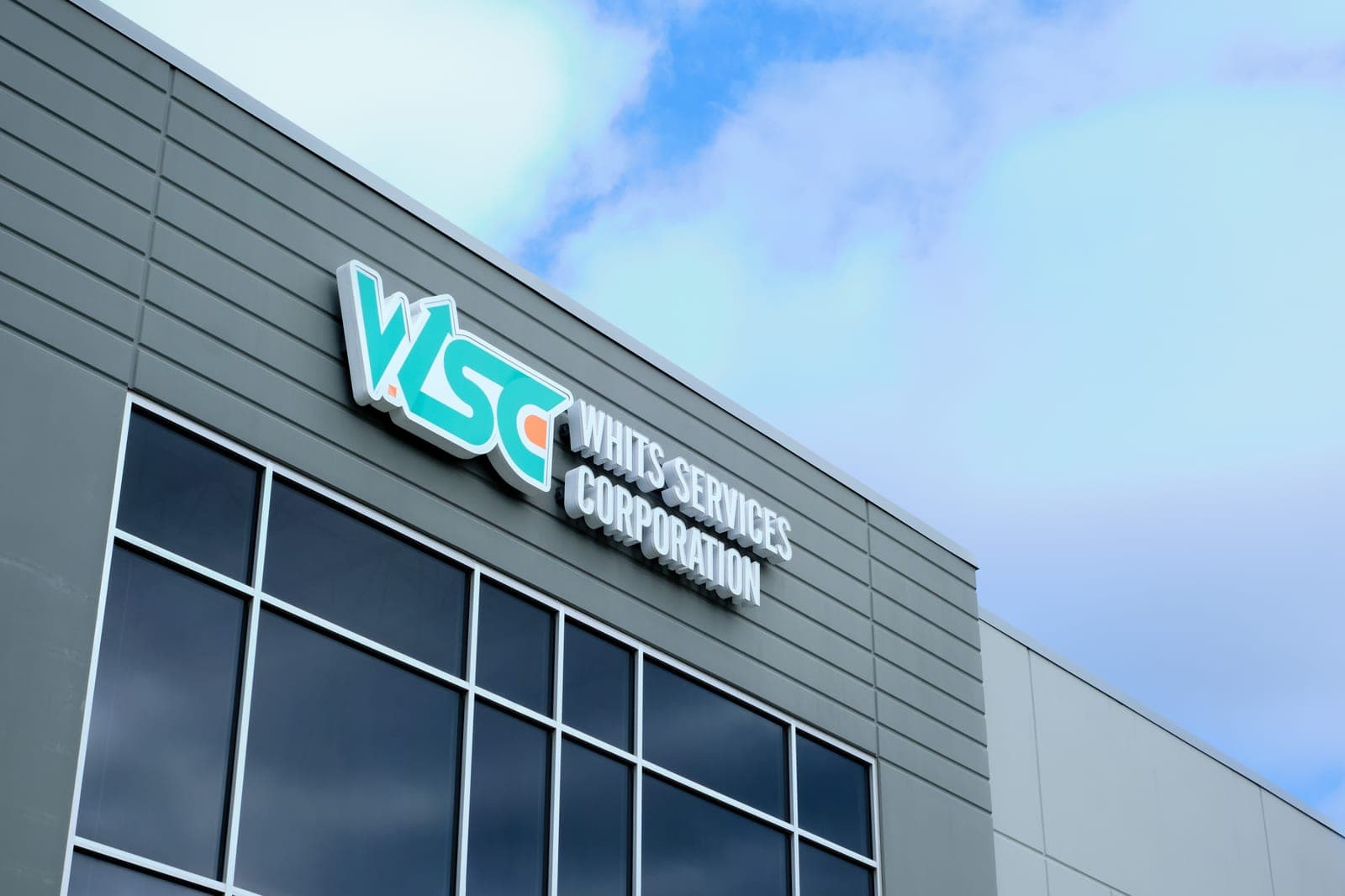 The WSC Whits Services Corporation sign on the gray facade of the company's facility in Bridgeton, Missouri, industrial building photography